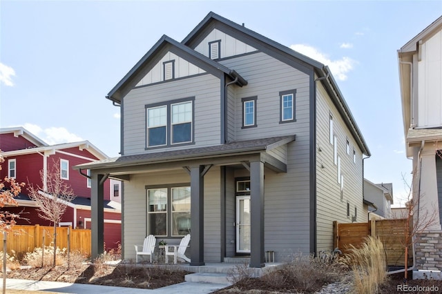 view of front facade featuring covered porch, fence, and board and batten siding