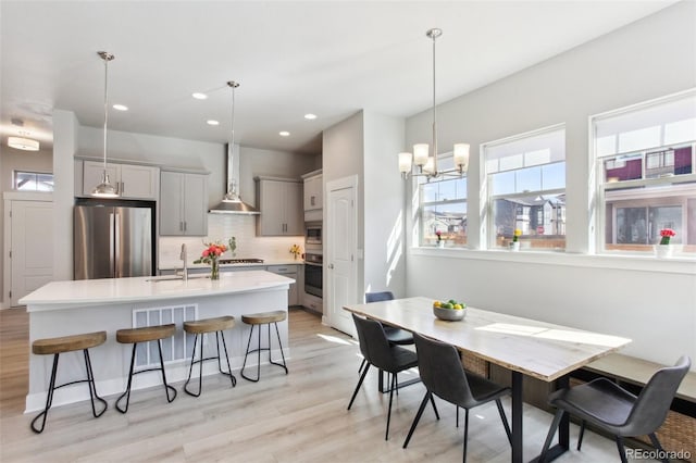 dining space with light wood-style floors, recessed lighting, and a chandelier