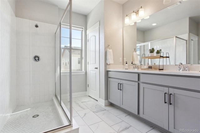 full bathroom with a sink, baseboards, marble finish floor, double vanity, and a stall shower