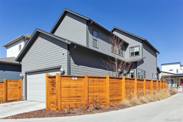 view of side of home featuring driveway and fence