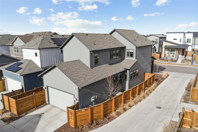 view of front facade with a fenced front yard, a residential view, and a shingled roof