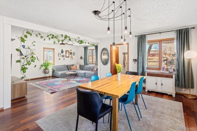 dining space featuring dark wood-type flooring and a textured ceiling