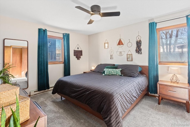 carpeted bedroom featuring a baseboard heating unit and ceiling fan