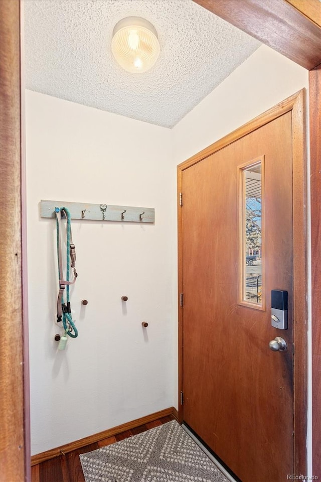 doorway to outside featuring a textured ceiling