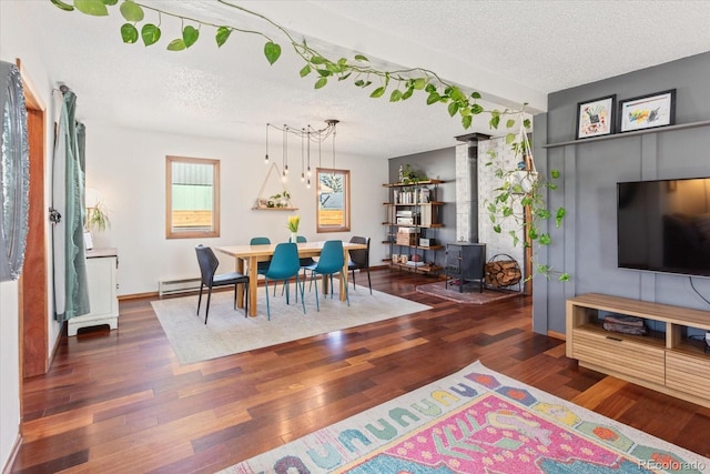 dining area with dark hardwood / wood-style floors, a textured ceiling, and a wood stove