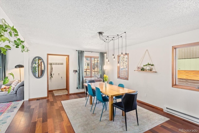 dining space featuring a baseboard heating unit, dark wood-type flooring, and a textured ceiling