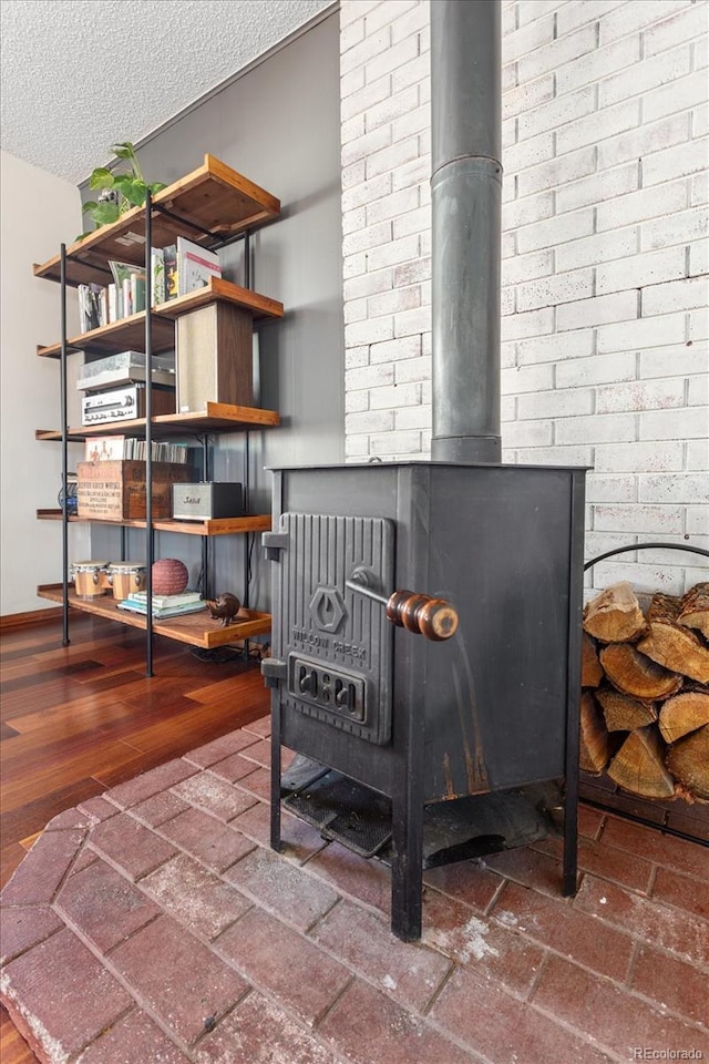 details with wood-type flooring, a wood stove, and a textured ceiling