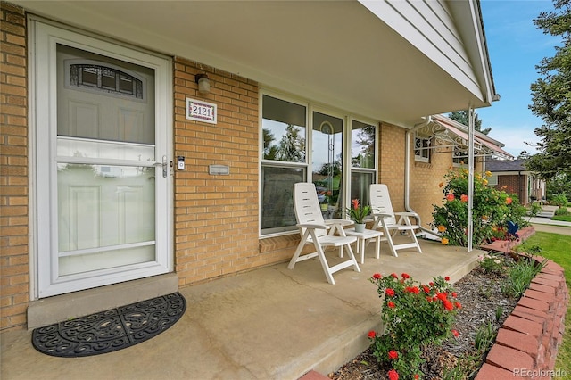 2121 W 73rd Pl, Denver, CO 80221 - doorway to property featuring brick siding and covered porch
