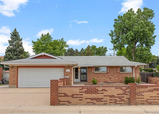 8205 Pennsylvania St, Denver, CO 80229 - ranch-style house with concrete driveway, a garage, brick siding, and a shingled roof