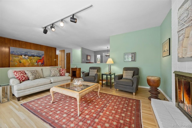 8205 Pennsylvania St, Denver, CO 80229 - living area featuring a brick fireplace, wood finished floors, rail lighting, and wooden walls