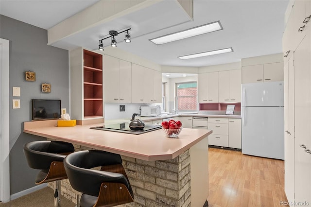 8205 Pennsylvania St, Denver, CO 80229 - kitchen with white appliances, a peninsula, white cabinetry, open shelves, and an office area