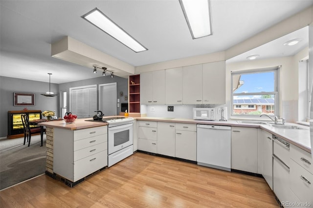 8205 Pennsylvania St, Denver, CO 80229 - kitchen featuring white appliances, a peninsula, white cabinets, light wood-type flooring, and light countertops