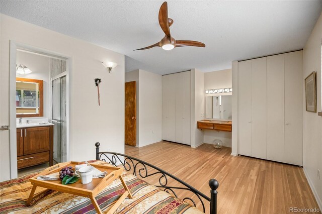 8205 Pennsylvania St, Denver, CO 80229 - bedroom featuring wood finished floors, ensuite bath, ceiling fan, and multiple closets