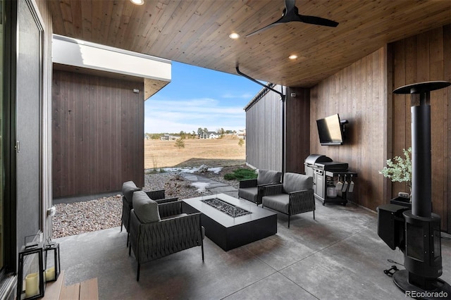 view of patio / terrace with ceiling fan and an outdoor living space with a fire pit