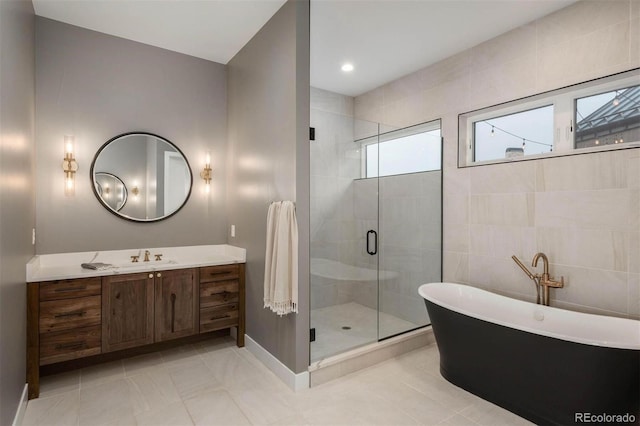 bathroom with tile patterned flooring, vanity, and shower with separate bathtub