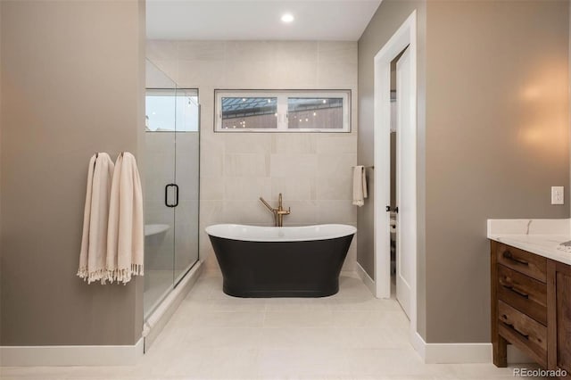 full bathroom with a freestanding tub, a stall shower, tile walls, tile patterned flooring, and vanity