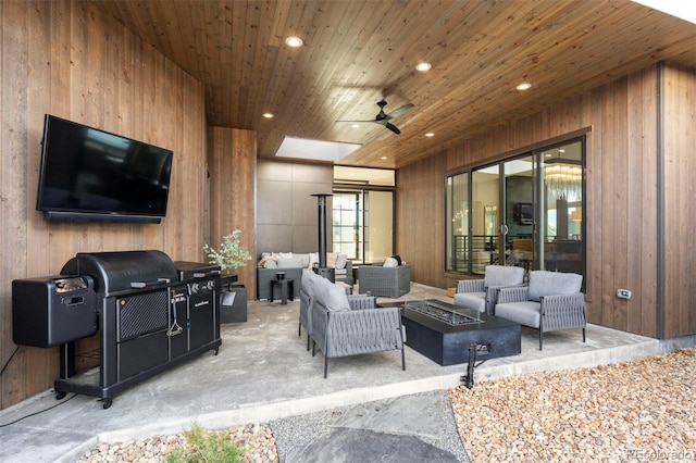 view of patio / terrace with grilling area, an outdoor living space with a fire pit, and ceiling fan