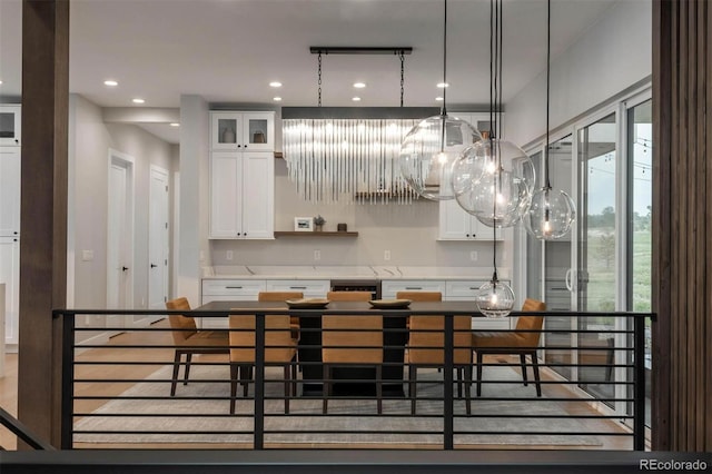 kitchen featuring decorative light fixtures, recessed lighting, white cabinets, glass insert cabinets, and a chandelier