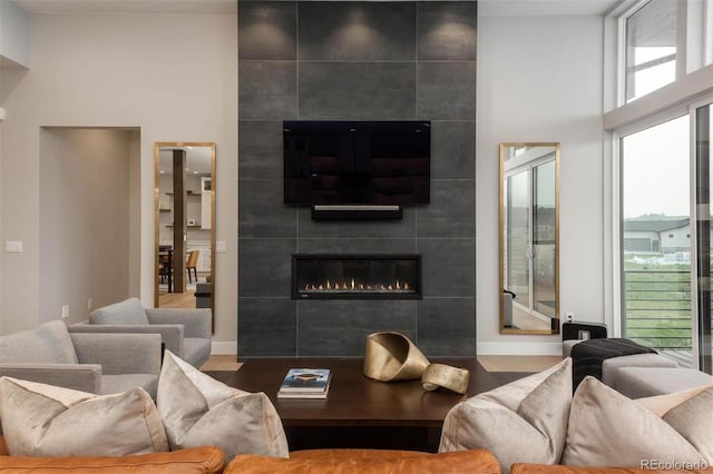 living room with wood finished floors, plenty of natural light, and a fireplace