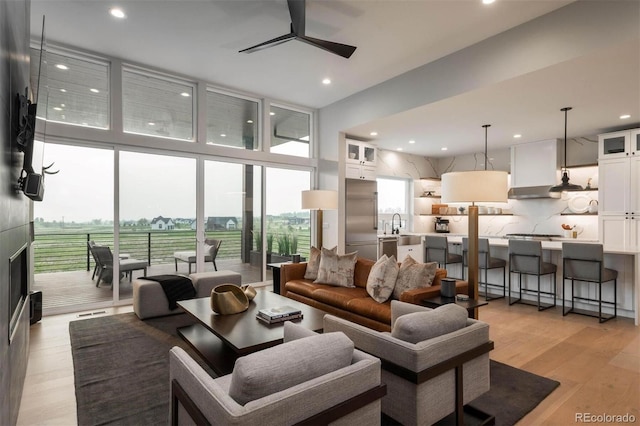living room with recessed lighting, floor to ceiling windows, light wood-style flooring, and a ceiling fan