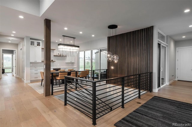 staircase featuring a notable chandelier, recessed lighting, baseboards, and wood finished floors