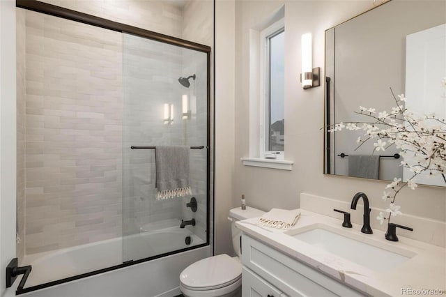 bathroom with vanity, toilet, and enclosed tub / shower combo
