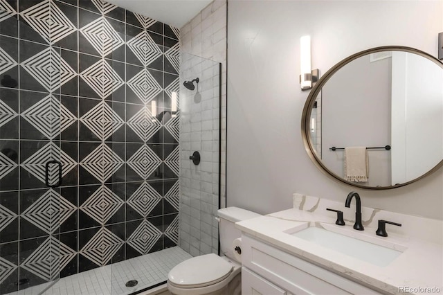 full bath featuring a tile shower, toilet, and vanity