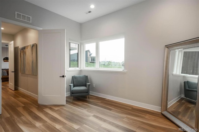 sitting room with visible vents, light wood-type flooring, and baseboards