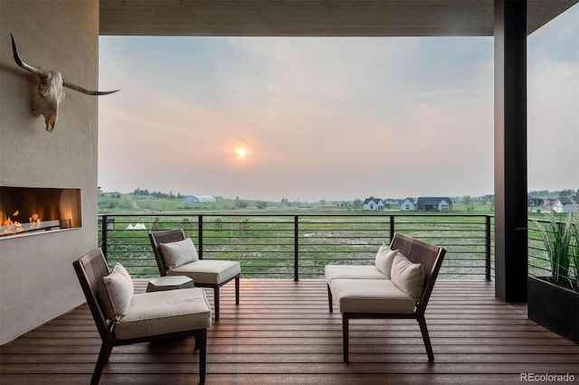 deck at dusk featuring an outdoor living space with a fireplace