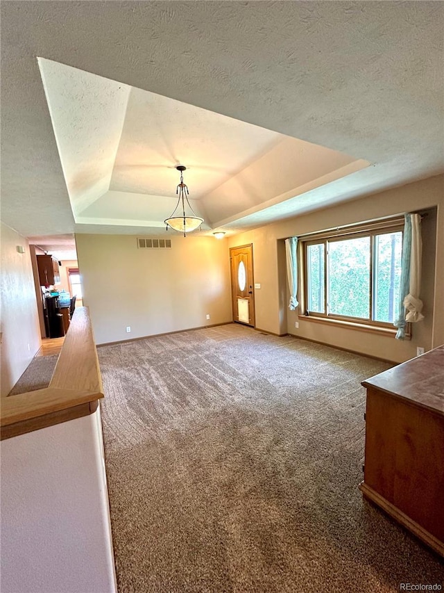 24938 County Road 18, Keenesburg, CO 80643 - unfurnished dining area featuring a tray ceiling, carpet, a textured ceiling, and baseboards