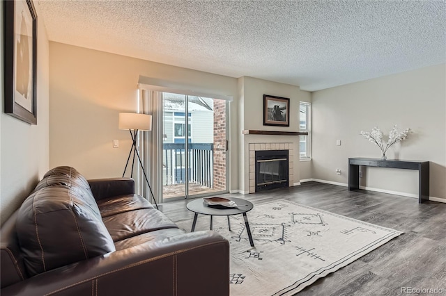 living room featuring dark wood-type flooring, a fireplace, and a textured ceiling