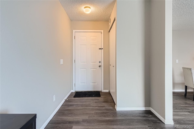 doorway to outside with dark hardwood / wood-style flooring and a textured ceiling