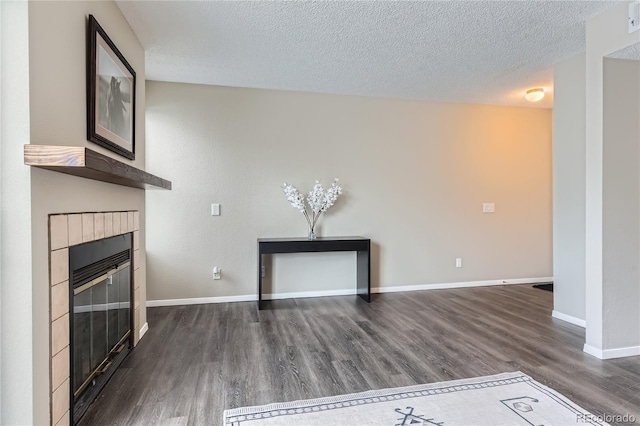 unfurnished living room featuring a fireplace, dark hardwood / wood-style flooring, and a textured ceiling