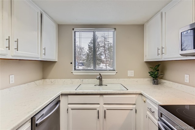 kitchen featuring white cabinets, stainless steel appliances, and a sink