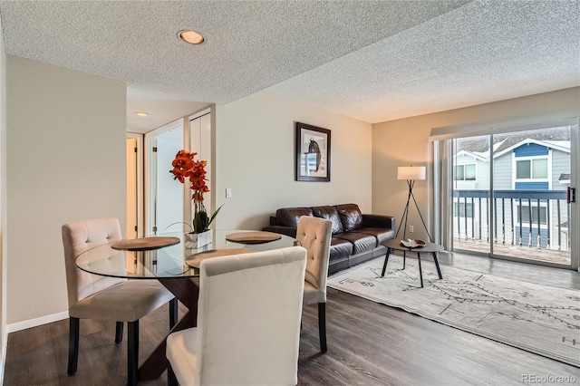 dining space with dark hardwood / wood-style floors and a textured ceiling