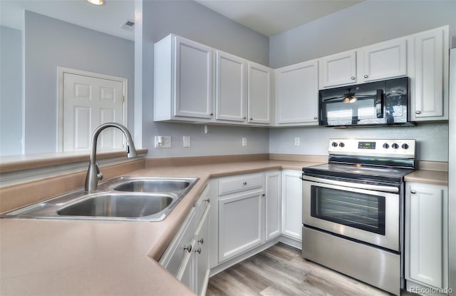 17205 Waterhouse Cir Unit C, Parker, CO 80134 - kitchen featuring black microwave, stainless steel range with electric stovetop, light countertops, and white cabinets