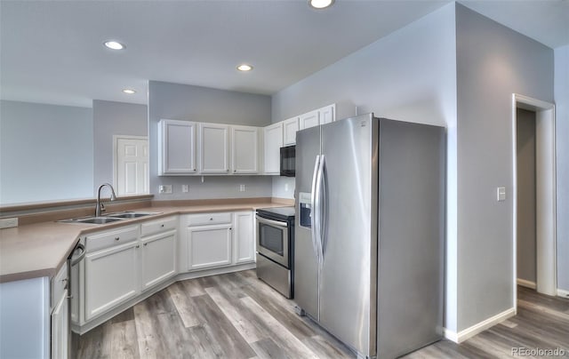 17205 Waterhouse Cir Unit C, Parker, CO 80134 - kitchen with appliances with stainless steel finishes, light wood-type flooring, recessed lighting, light countertops, and white cabinets