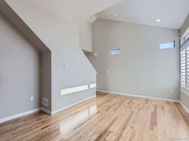 unfurnished living room with light hardwood / wood-style floors and lofted ceiling