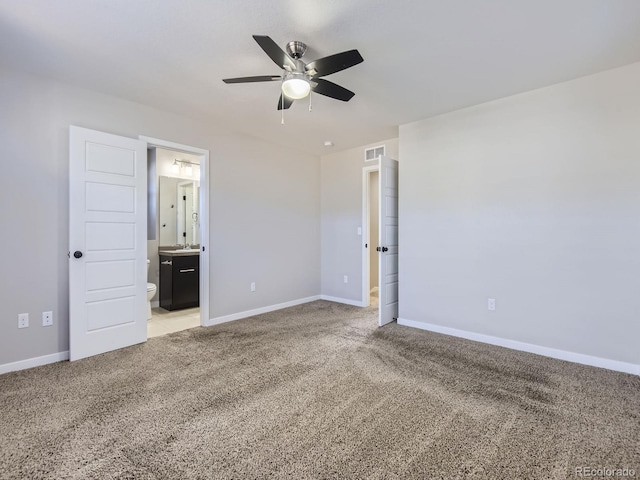 unfurnished bedroom with ensuite bath, ceiling fan, and carpet