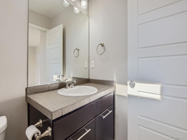 bathroom featuring vanity and toilet