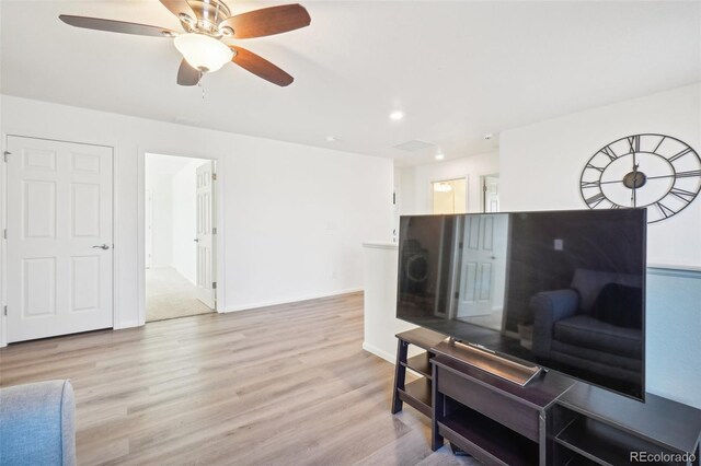 living room featuring light hardwood / wood-style flooring and ceiling fan