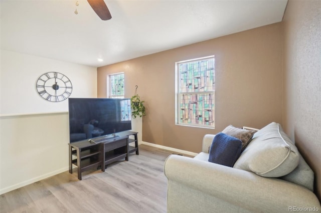 living room featuring light hardwood / wood-style floors and ceiling fan