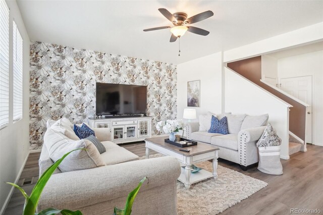 living room featuring wood-type flooring and ceiling fan