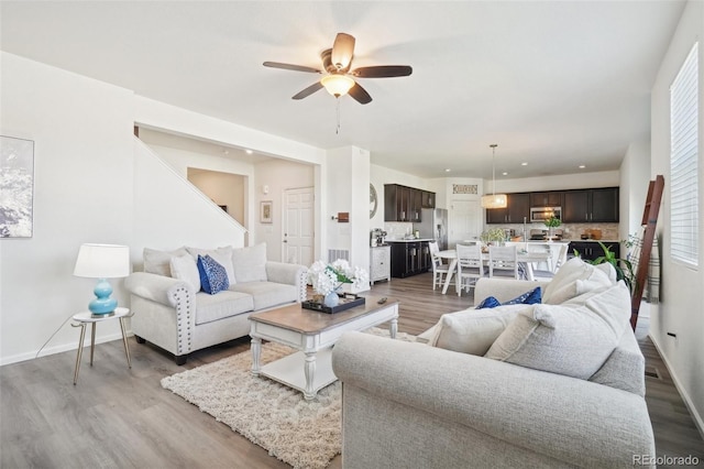 living room featuring hardwood / wood-style floors and ceiling fan