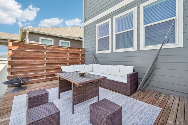 wooden terrace with an outdoor living space