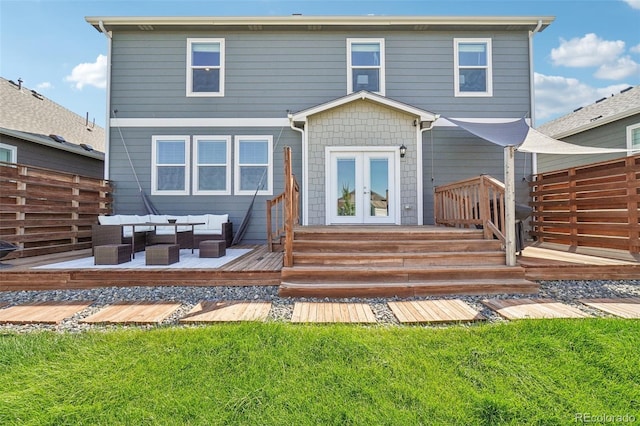 back of house featuring an outdoor living space, a wooden deck, a lawn, and french doors