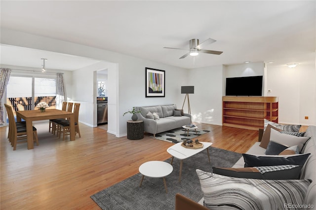 living room with ceiling fan and light hardwood / wood-style flooring