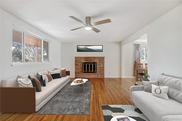 living room with hardwood / wood-style flooring, ceiling fan, and a fireplace