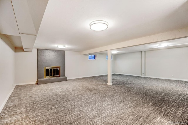 basement with carpet flooring and a large fireplace