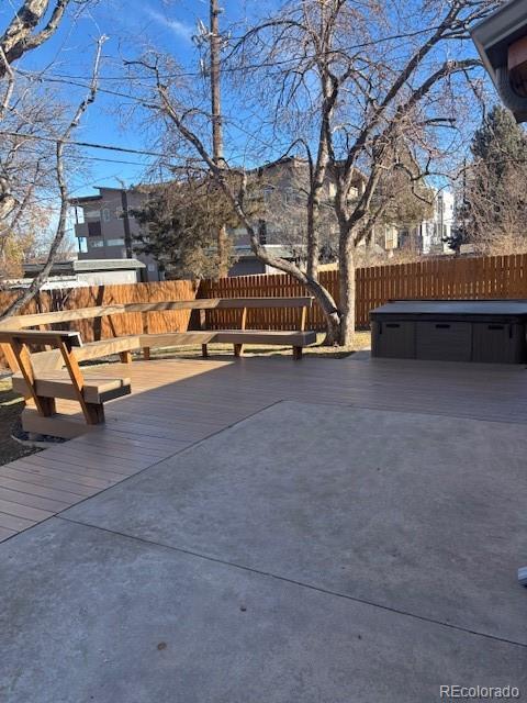 view of patio with a hot tub and a deck